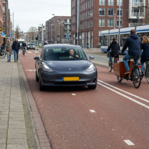 Tesla på hollandsk vej i almindelig trafik med fører synlig bag rattet