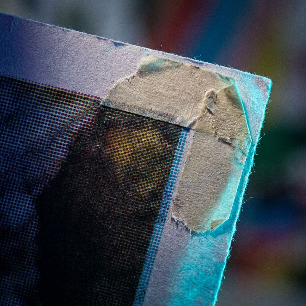 Makro af printudkast med tydelig trykfarveafvigelse og slidt tape; visuelt bevis på brand‑inkonsistens.