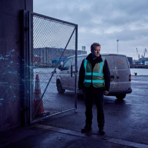 Driftsleder foran afspærret teknisk dør i nordisk havnemiljø, dyb indigo og cyan accenter, stemning af beslutningspres