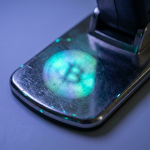 En dansk SME‑ejer står udenfor sin butik med telefon i hånden, kunder venter i kø; mørk indigo belysning med cyan/grønne signalaccents, subtil data‑pulse overlay, realistisk reportage‑følelse.